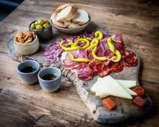 Our Andalus Sharing Board features the finest Iberico charcuterie, aged manchego, Valencian almonds, olives from Jaen and traditional accompaniments like membrillo and spicy guindilla peppers. As a light lunch for 2 on the terrace with a glass of cold white wine, it's perfection.